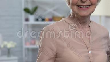 爱笑的老奶奶对着镜头竖起大拇指，对健康保险很满意